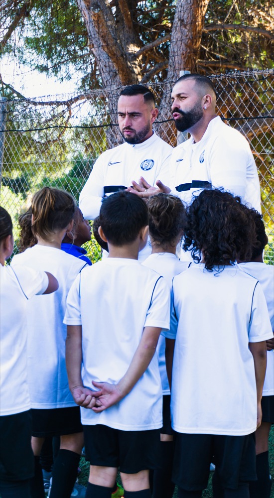 Coaches leading a team huddle during an organized sports activity